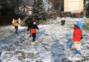 dzieci biegające po ogrodzie przedszkolnym