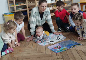 Mama Kacpra czyta książkę a dzieci słuchają