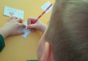 chłopiec koloruje talony dla babci i dziadka