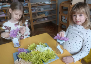 dziewczynki wybierają kwiaty do słoika