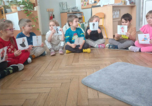 dzieci trzymaja w rękach zdjęcia człowiek