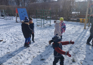 Na zdjęciu widzimy grupkę dzieci, które tańczą do muzyki. Dwójka chłopców i dwie dziewczynki tańczy w parze.