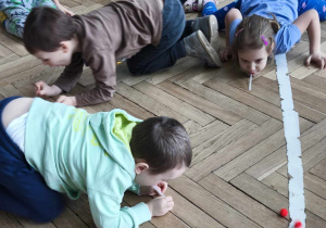 Dzieci wykonują doświadczenie z powietrzem i pomponem