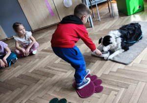 Dziecko karmi psa smaczkiem podając z miseczki