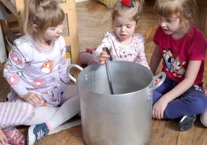 dziewczynka miesz chochlą w metalowym garnku
