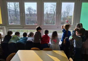 dzieci obserują pogodę za oknem