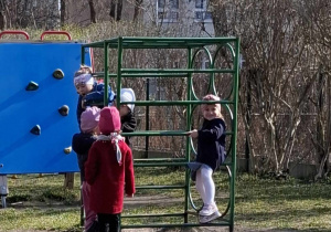dziweczynki stoją przy srzęcie spotrowym w ogódku