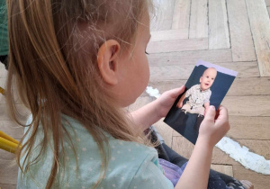 urodziny chłopca w grupie, dziewczynka ogląda zdjęcie