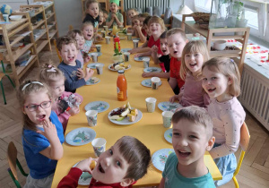 dzieci siedzą przy stole urodzinowym