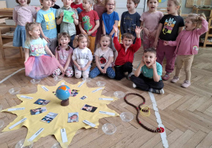 zdjęcie grupowe dzieci, przed nimi leży słoneczko urodzinowe