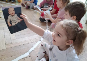 rodziny chłopca w grupie, dziewczynka ogląda zdjęcie