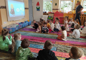 Na zdjęciu widzimy grupkę dzieci, które oglądają film na tablicy interaktywnej z serii sieciaki.pl.