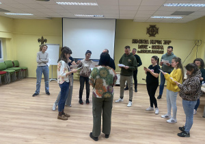 Zdjęcie przedstawia grupę rodziców podczas próby.
