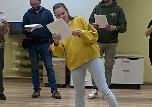 Zdjęcie przedstawia kobietę podczas próby, czytającą swoją rolę.