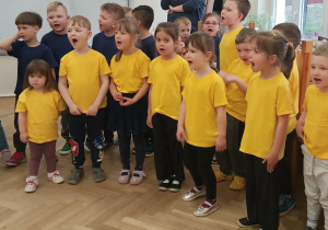 Dzieci stoją i śpiewają hymn "Niebieskich Igrzysk"