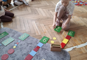 dziewczynka trzyma napisaną cyfrę dwa
