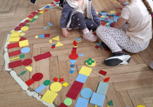 dziewczynki układają drzewa z figur geometrychnych