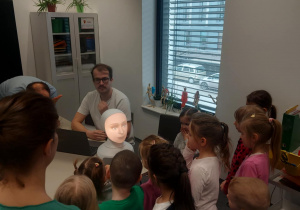 Grupa dzieci zadająca pytania robotowi
