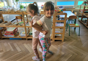 Zdjęcie przedstawia dzieci wykonujące ćwiczenia ruchowe z elementami jogi.