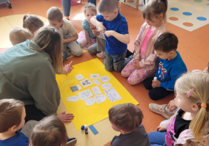 Na zdjęciu widzimy dzieci, które segregują i przyklejają na żółty karton dobre i złe zachowania ludzi względem środowiska.