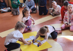 Na zdjęciu widzimy dzieci, które segregują i przyklejają na żółty karton dobre i złe zachowania ludzi względem środowiska.