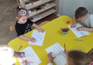 Na zdjęciu widzimy dzieci, które kolorują opaskę konia.