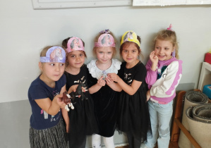 Na zdjęciu widzimy dziewczynki, które pozują do zdjęcia w opaskach konia i figurkami konia.