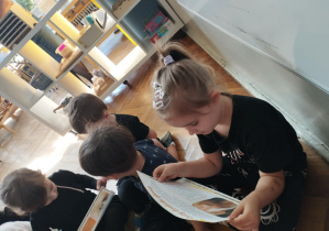 Na zdjęciu widzimy dziewczynkę, która ogląda ilustrację przedstawiającą oczy konia i informacje dotyczącą wzroku koni.