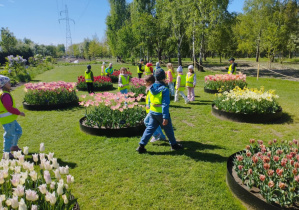 Na zdjęciu widzimy dzieci, które wybrierają najładniejszą rabatę z tulipanami.