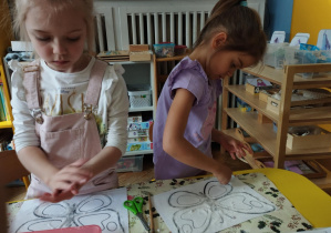 Na zdjęciu widzimy dwie dziewczynki, które tworzą pracę plastyczną metodą "sól i klej".