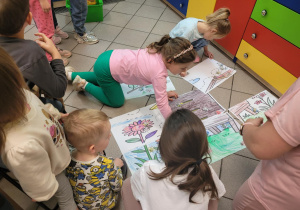 Zdjęcie przedstawia dzieci układające pracę plastyczną z części.