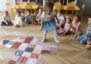Dziecko szukające na macie właściwy fragment obrazujący sierść psa