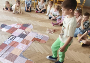 Dziecko szukające na macie właściwy fragment obrazujący sierść psa