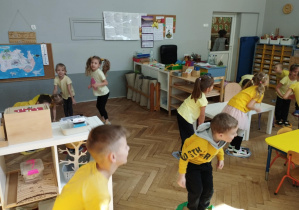 Na zdjęciu widzimy grupkę dzieci, które biorą udział w zabawie "Z kiwatka na kwiatek".