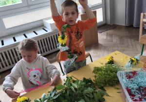 Dzieci wykonujące wianki z roślin