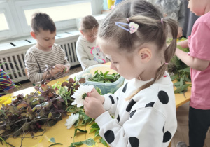 Dzieci wykonujące wianki z roślin