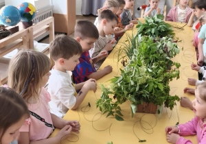 Mama Zosi tłumacząca sposób wykonywania wianków.