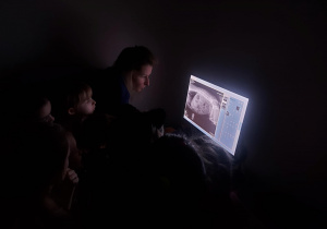 Na zdjęciu dzieci oglądają zdjęcia RTG