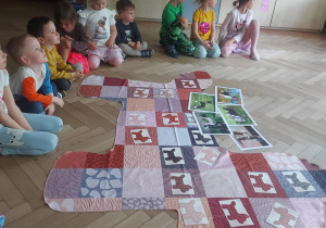 Na zdjęciu widać matę a wokół niej zebrane dzieci