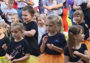 Zdjęcie przedstawia dzieci i rodziców wykonujących ruchy do piosenki.