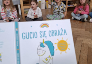 dzieci patrzą na obrazek w książce