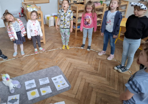 dzieci stojąc wykonują ćwiczenia oddechowe