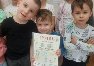 Na zdjęciu widać dzieci trzymające dyplom dla grupy