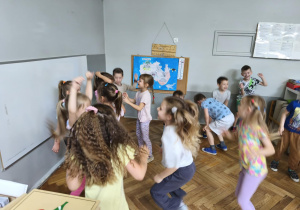 Na zdjeciu widzimy grupkę dzieci, które uczestniczą w zajęciach tanecznych połączonych z elementami Zumby.