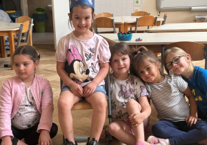 Zdjęcie przedstawia Jubilatkę w koronie siedzącą na krześle, wśród dzieci.