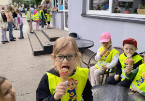 Zdjęcie przedstawia chłopca jedzącego lody.
