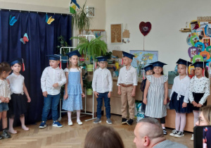Zdjęcie przedstawia absolwentów w biretach.