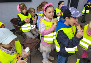 Zdjęcie przedstawia dzieci jedzące lody.