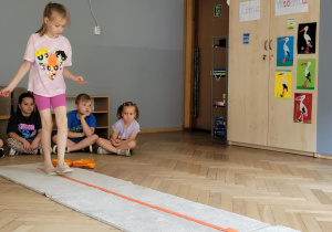 Zdjęcie przedstawia dziecko idące po taśmie.