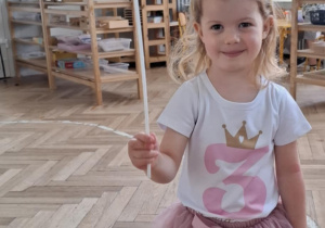 dziewczynka trzyma w ręku balonik z cyfrą 3